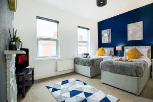 北安普敦的住宿－Modern House in Prime Location - Free Parking, Fast WiFi and Smart TV by Yoko Property，一间卧室设有两张床和蓝色的墙壁