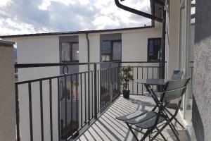 a balcony with a table and two chairs on it at Living Home, apartament cu două dormitoare și două băi in Cisnădie