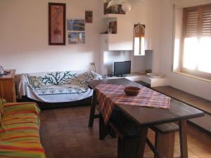 a living room with a table and a couch at Borgo Spiaggia Isola Rossa in Isola Rossa