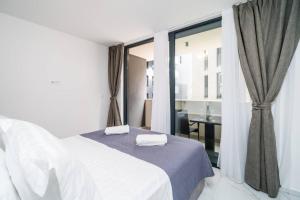 a bedroom with a white bed and a window at Luxury Downtown West Apartment Dubrovnik in Dubrovnik