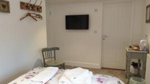 a room with a bed with a tv on the wall at Argyll House Bed and Breakfast in Westleton
