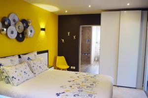 a bedroom with a bed and a yellow wall at Gîte Autour d'Opale in Cucq