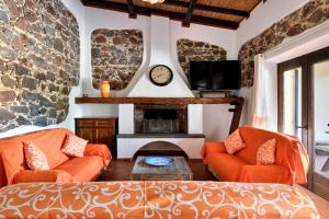 uma sala de estar com dois sofás laranja e uma lareira em Casa sul Lago em Dorgali