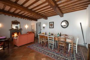 sala de estar con mesa, sillas y chimenea en Villa con Piscina san Gimignano, en Strada