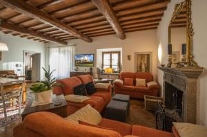 sala de estar con muebles de color naranja y chimenea en Villa con Piscina san Gimignano, en Strada
