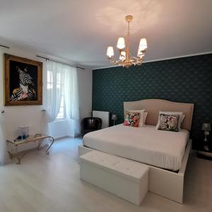 a bedroom with a white bed and a green wall at La Maison Blanche in Blaye