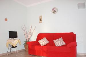 a red couch with two pillows in a living room at La Casa Di Pericle in Brenzone sul Garda