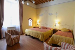 a hotel room with two beds and a chair at Hotel Di Stefano in Pisa +37 photos