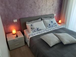 een slaapkamer met een bed met twee lampen op tafels bij Appartamenti Villa Gloria in Peschiera del Garda