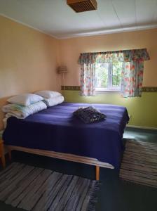 a bedroom with a large blue bed with a window at Sassi Talu Horsefarm in Pärnumaa