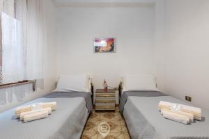 dos camas sentadas una al lado de la otra en una habitación en House Antonella - Wonderful Holidays on a Budget en Gonnesa
