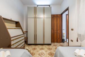1 dormitorio con 2 camas y nevera grande en House Antonella - Wonderful Holidays on a Budget en Gonnesa