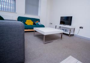 a living room with a couch and a coffee table at Cosy Executive City Apartment 2 in Doncaster