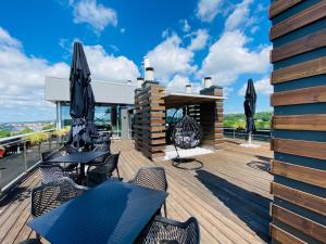 a patio with tables and chairs on a wooden deck at IBIS Styles Kaunas Centre in Kaunas