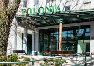 a building with benches in front of a building at M-Apartamenty w Hotelu Polonia in Kołobrzeg