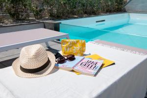 a picnic table with a hat and a book and sunglasses at StayMela Apartments - Birkirkara in Birkirkara