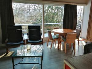 uma sala de estar com uma mesa e cadeiras e uma janela em Au repos de Zoé em Waulsort