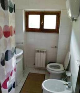 baño con aseo y lavabo y ventana en La fonte di Gaiche, en Piegaro