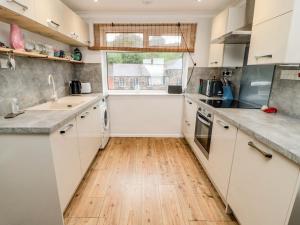 eine Küche mit weißen Schränken und Holzböden in der Unterkunft Sea Snug in Berwick-Upon-Tweed