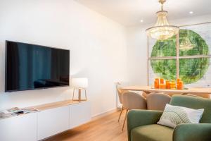 ein Wohnzimmer mit einem Flachbild-TV an der Wand in der Unterkunft Genteel Home Alhóndiga Granada in Granada