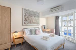 a bedroom with a white bed with towels on it at 3 Bedroom Jesus Green Townhouse with Parking in Cambridge