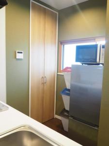 a kitchen with a refrigerator with a microwave and a window at Harbour Inn & Suites - Vacation STAY 8829 in Niigata