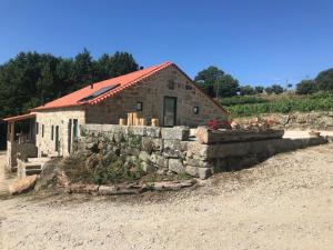 a small stone building with a red roof at Quinta Casa do Retiro in Penalva do Castelo