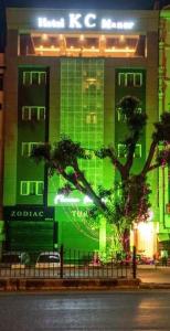 un edificio verde con un árbol delante de él en KC MANOR, en Jamshedpur