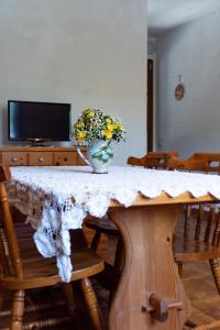 stół jadalny z wazonem kwiatów w obiekcie Casa Vacanze - Residenza San Luca w mieście Muro Lucano