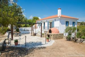 a white house with a pizza oven in front of it at Gerani Maison Agios Aimilianos beautiful view in Porto Heli