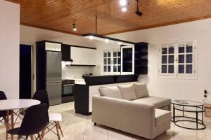 uma sala de estar com um sofá e uma cozinha em Gerani Maison Agios Aimilianos beautiful view em Porto Heli