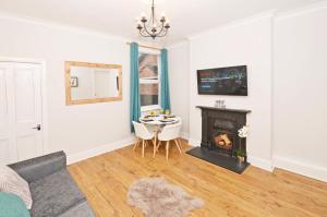 a living room with a table and a fireplace at Tranquil Oasis in the Heart of the Stoke-on-Trent! in Stoke on Trent