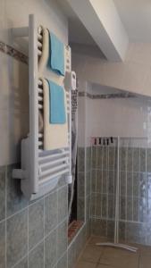 a bathroom with a stack of towels on a rack at Le Petit Séguret in Le Puy en Velay