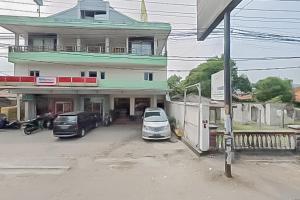 a building with cars parked in a parking lot at RedDoorz near Pantai Citepus Pelabuhan Ratu in Sukabumi