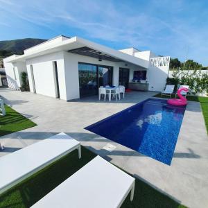 eine Villa mit einem Pool und einem Haus in der Unterkunft Villa Jasmin in Finestrat