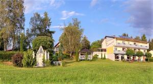 a large house in a field with a building at Pension Carinthia Klopeiner See in Sankt Kanzian