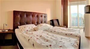 a bedroom with a large bed with a leather headboard at Pension Carinthia Klopeiner See in Sankt Kanzian