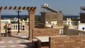 un patio con una valla de ladrillo y un banco en La Reine Dahab Hotel en Dahab