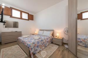 Dormitorio pequeño con 2 camas y 2 lámparas en Mary's House - WiFi & Private Parking, en Gonnesa