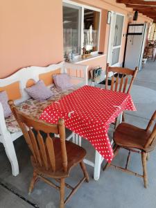 una mesa con un paño de lunares rojo y blanco en Nagymama Házikója, en Tiszasas