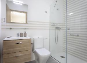 a bathroom with a toilet and a glass shower at Playa Ribeiría apartamento vacacional in Tapia de Casariego +22 photos