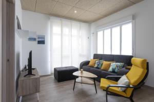 ein Wohnzimmer mit einem Sofa und einem Tisch in der Unterkunft Playa Ribeiría apartamento vacacional in Tapia de Casariego