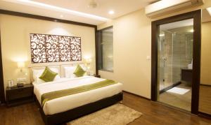 a bedroom with a bed and a glass shower at KC MANOR in Jamshedpur