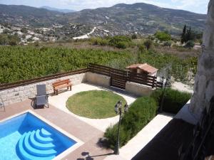 a swimming pool with a picnic table and a bench at Softades Cottage in Omodos