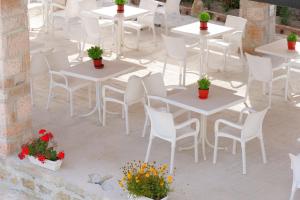 een uitzicht op witte tafels en stoelen en potplanten bij Villa JOSANA in Sarandë