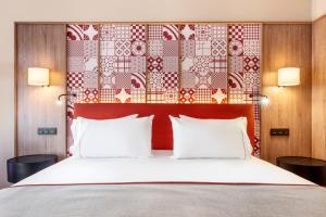 a bedroom with a large bed with two pillows at Eurostars Guadalquivir in Seville