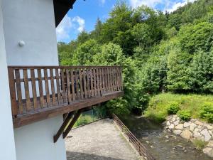 balkon z drewnianą ławką nad rzeką w obiekcie Ondraszek-Pokoje Gościnne w Szczyrku