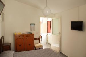- une chambre avec un lit, un réfrigérateur et une télévision dans l'établissement Casa Normanna, à Acerenza