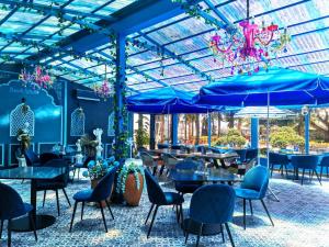 un ristorante con sedie blu, tavoli e ombrelloni blu di Beach Walk Boutique Resort a Bangsaen