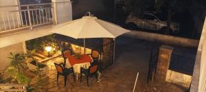 a porch with a table and an umbrella at Vanta Studio in Limenas